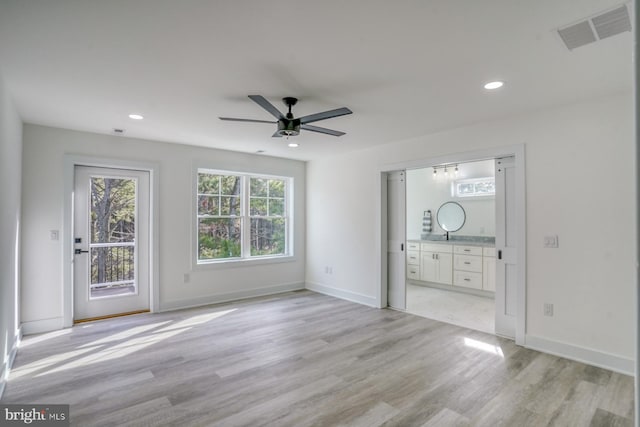 unfurnished living room with ceiling fan and light hardwood / wood-style flooring