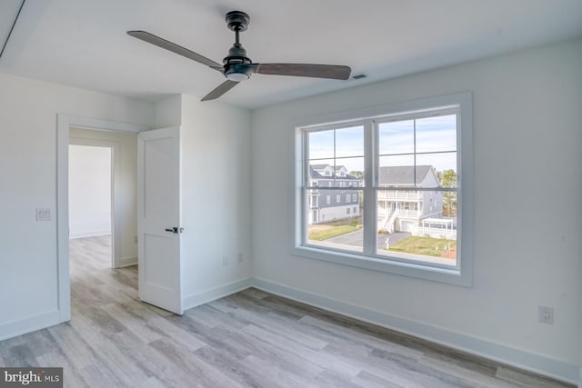 empty room with ceiling fan and light wood-type flooring