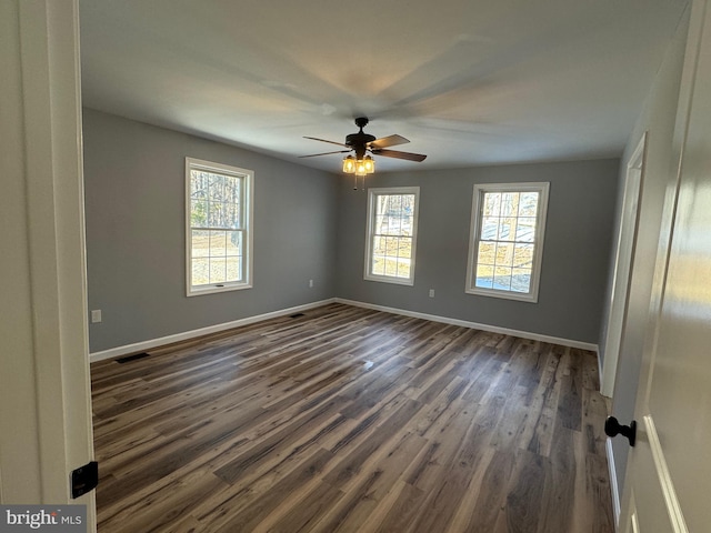 empty room with dark wood-type flooring and ceiling fan