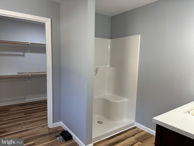 bathroom with vanity, wood-type flooring, and walk in shower