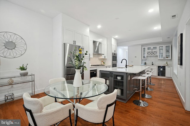 dining space featuring dark hardwood / wood-style floors, sink, and beverage cooler