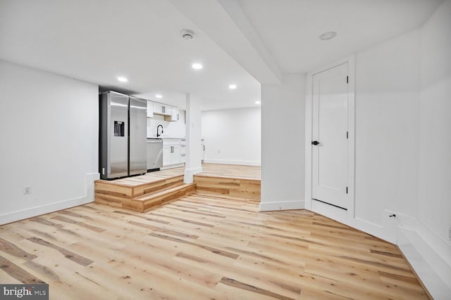 unfurnished living room featuring light hardwood / wood-style floors and sink