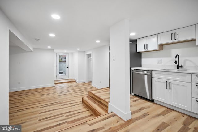 kitchen with light hardwood / wood-style floors, sink, white cabinetry, and stainless steel dishwasher