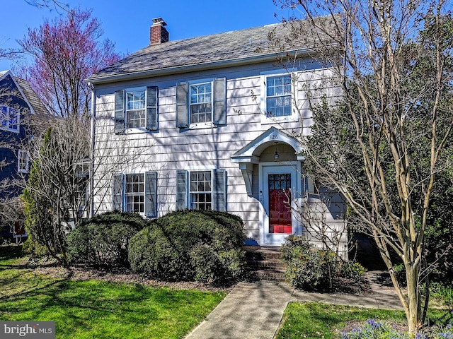 colonial house featuring a front lawn