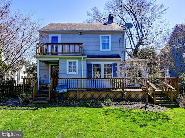 back of property featuring a deck and a lawn