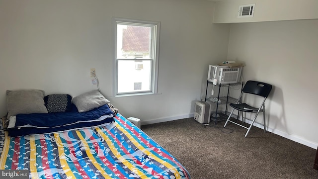 bedroom featuring a wall mounted air conditioner and dark colored carpet