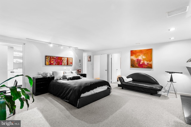 carpeted bedroom featuring rail lighting