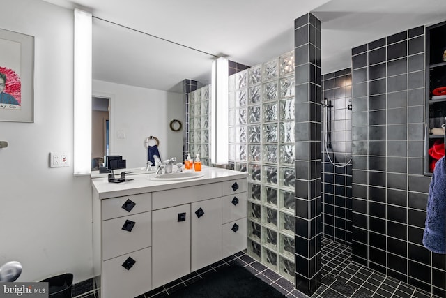 bathroom with tile floors, vanity, and a tile shower