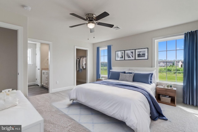 bedroom with ceiling fan, a spacious closet, ensuite bathroom, a closet, and hardwood / wood-style flooring