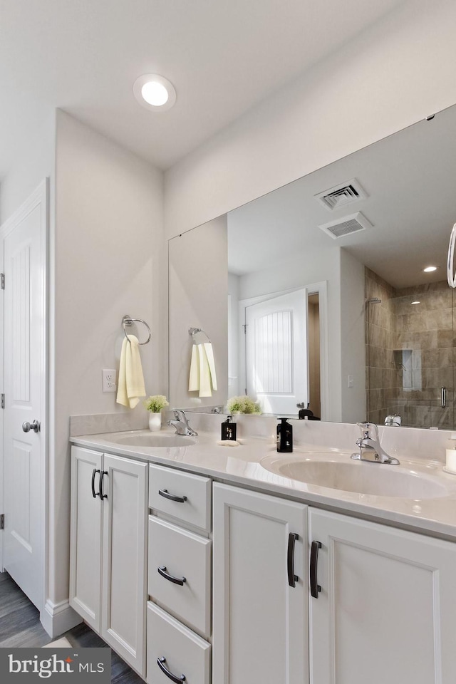 bathroom featuring hardwood / wood-style floors, vanity, and walk in shower