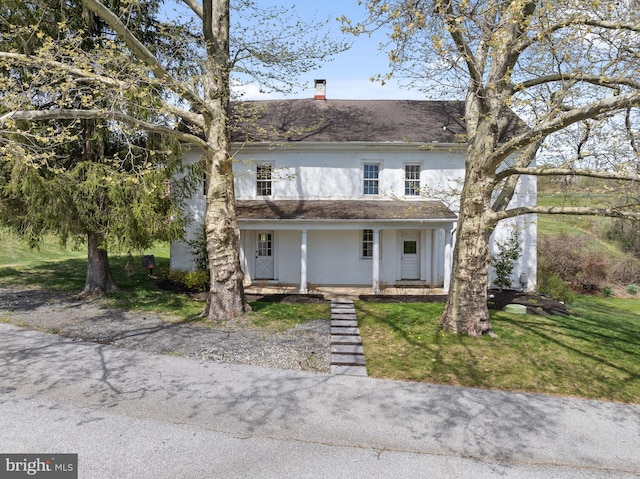 view of front of property featuring covered porch and a front yard