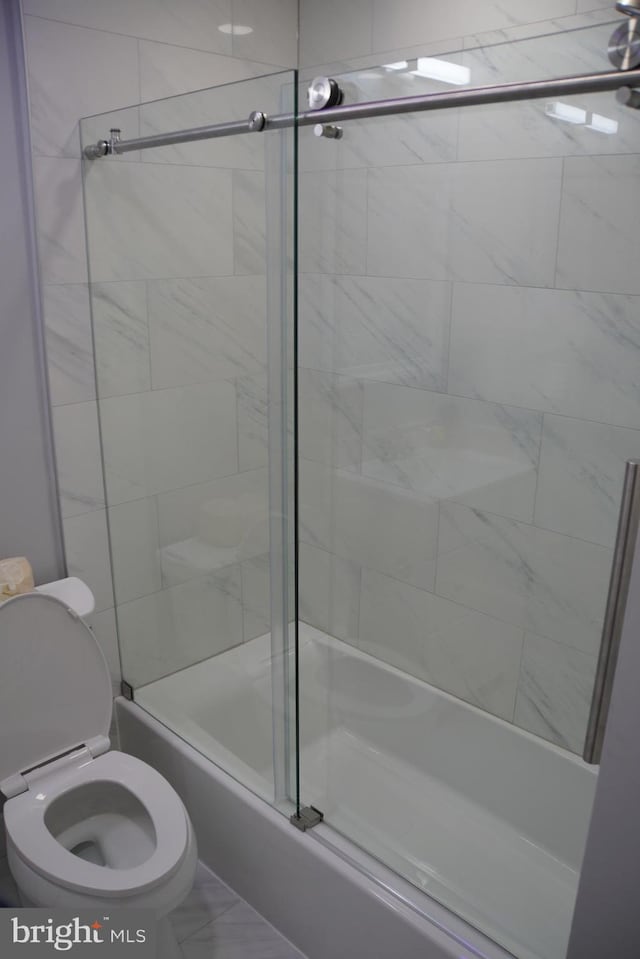 bathroom with tile flooring, enclosed tub / shower combo, and toilet