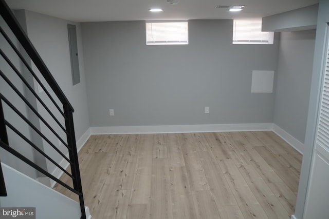 basement featuring a wealth of natural light and light hardwood / wood-style floors