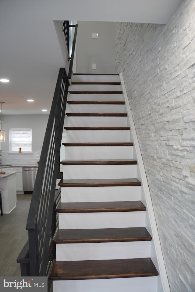 stairs featuring dark hardwood / wood-style floors and sink