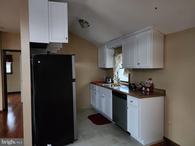 kitchen with fridge, light tile flooring, white cabinetry, and stainless steel dishwasher