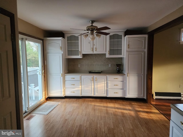 kitchen with light hardwood / wood-style flooring, backsplash, white cabinetry, and ceiling fan