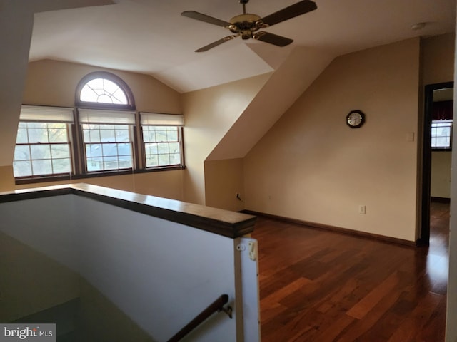 staircase featuring dark hardwood / wood-style flooring, ceiling fan, and lofted ceiling