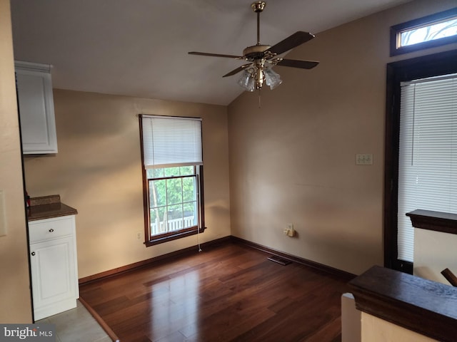 spare room featuring ceiling fan, dark hardwood / wood-style flooring, and vaulted ceiling