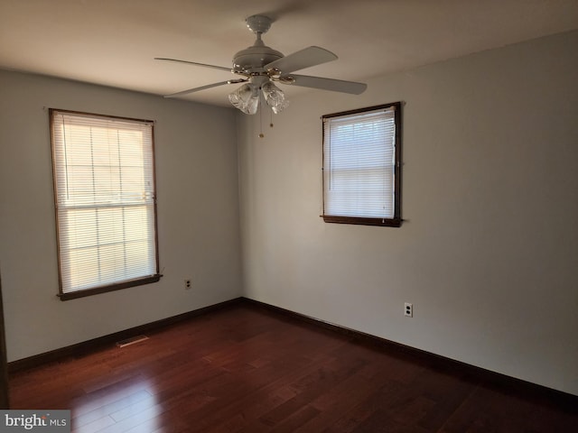 spare room with dark wood-type flooring and ceiling fan