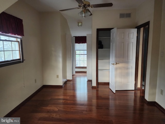 unfurnished bedroom featuring dark hardwood / wood-style flooring, ceiling fan, and multiple windows