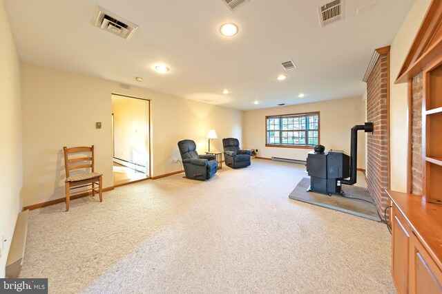 sitting room with visible vents, carpet, and a wood stove