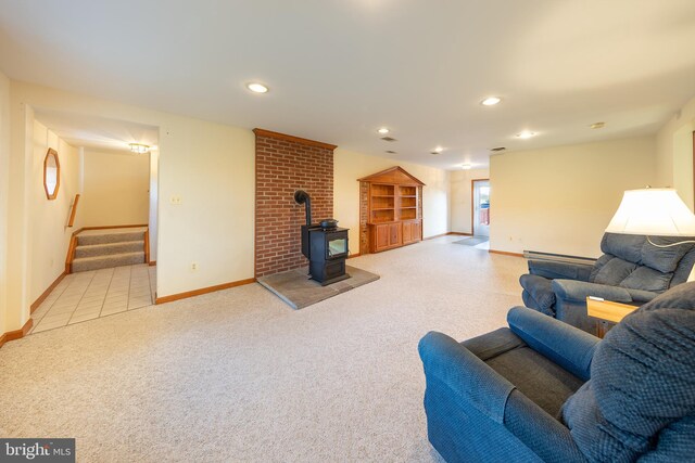 carpeted living area with a wood stove, baseboards, baseboard heating, stairway, and recessed lighting