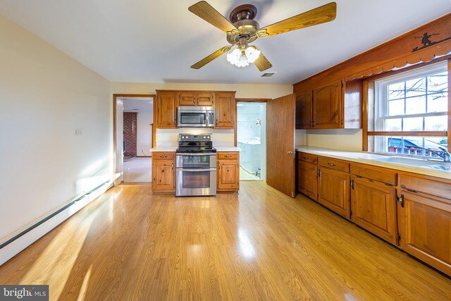 kitchen with visible vents, light countertops, a baseboard heating unit, brown cabinets, and stainless steel appliances