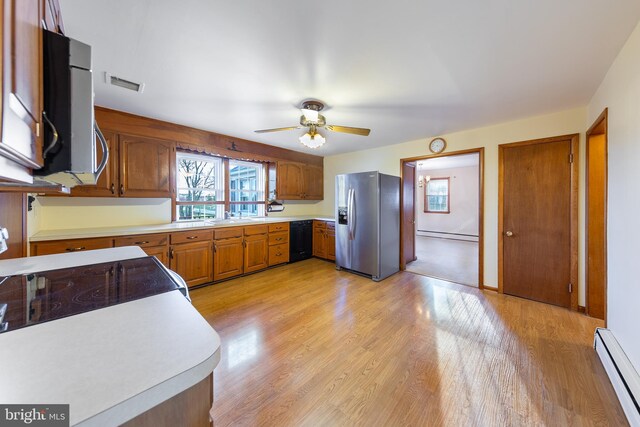 kitchen with a healthy amount of sunlight, baseboard heating, stainless steel appliances, and visible vents