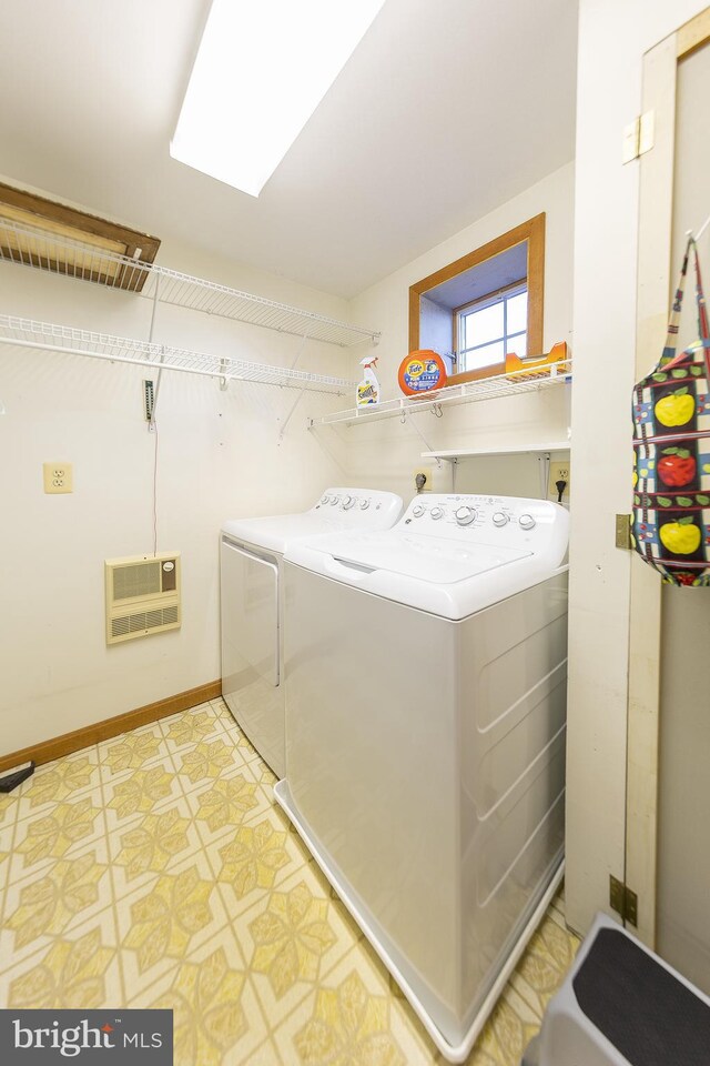 clothes washing area featuring heating unit, baseboards, laundry area, and independent washer and dryer