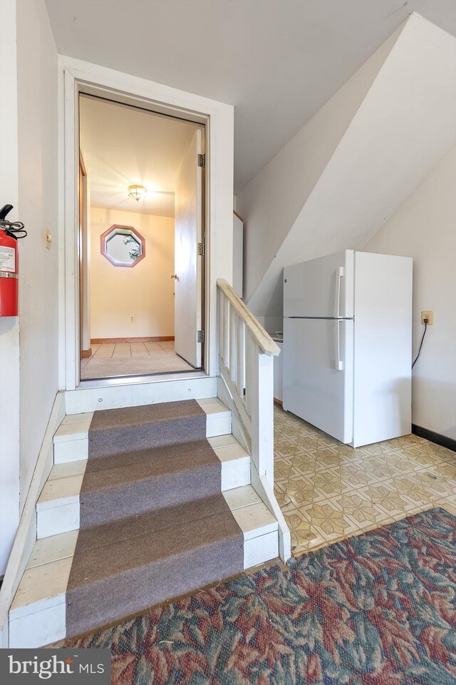stairway featuring carpet floors and baseboards