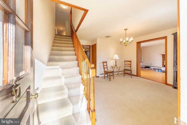 stairway with an inviting chandelier, carpet flooring, a baseboard heating unit, and visible vents