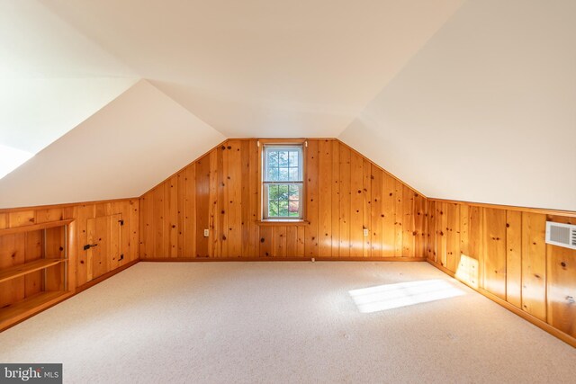 additional living space featuring carpet floors, wood walls, visible vents, and vaulted ceiling