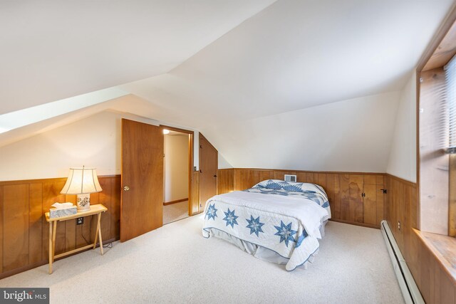 bedroom featuring wainscoting, wooden walls, a baseboard heating unit, carpet flooring, and vaulted ceiling