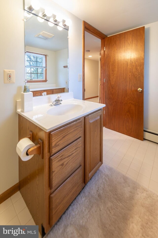 bathroom featuring vanity, a baseboard heating unit, and tile patterned floors