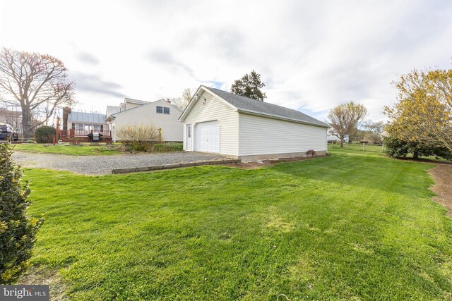 view of yard with an outdoor structure, a wooden deck, fence, and a detached garage