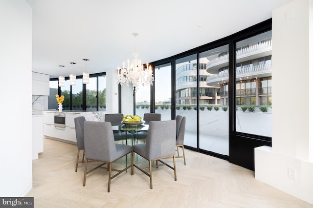 dining room with an inviting chandelier, light parquet flooring, and floor to ceiling windows