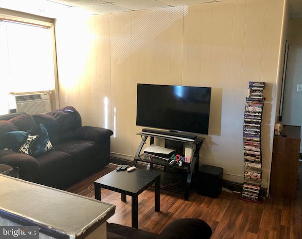 living room with dark hardwood / wood-style floors and a wealth of natural light