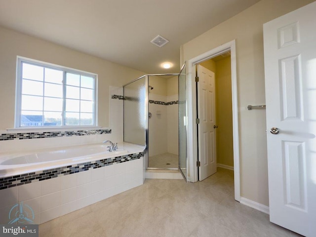 bathroom featuring shower with separate bathtub and tile floors