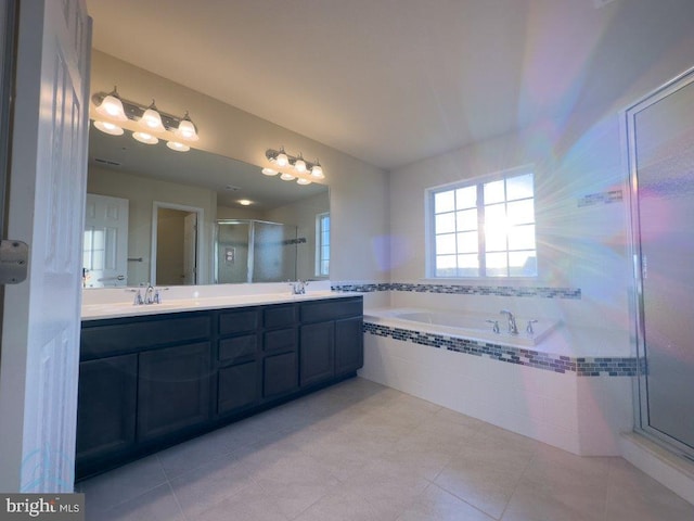 bathroom with tile flooring, dual sinks, independent shower and bath, and vanity with extensive cabinet space