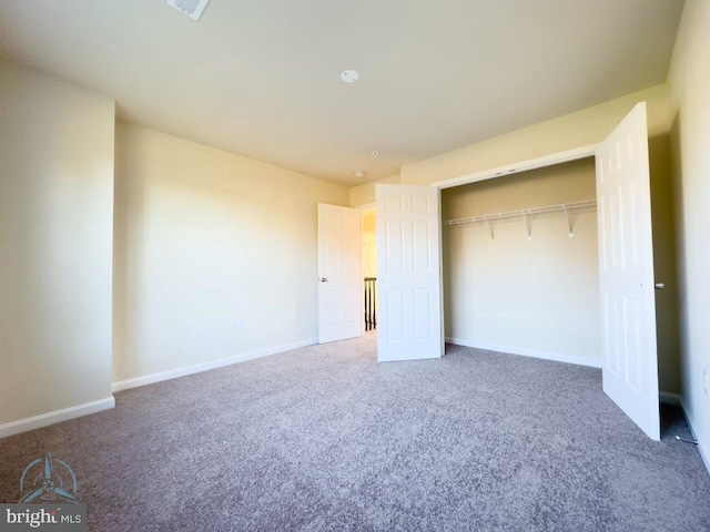 unfurnished bedroom featuring light carpet and a closet