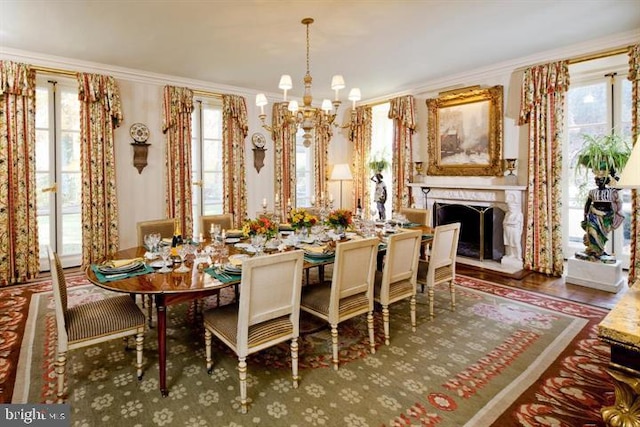 dining room with a healthy amount of sunlight, a notable chandelier, dark wood-type flooring, and ornamental molding