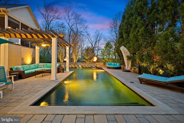 pool at dusk featuring outdoor lounge area, a patio area, and a pergola