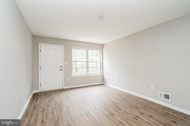 empty room with light hardwood / wood-style flooring