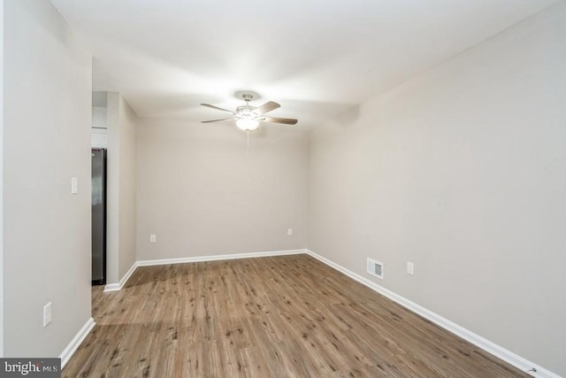 empty room with ceiling fan and light hardwood / wood-style flooring