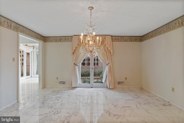 spare room featuring light tile floors and a chandelier