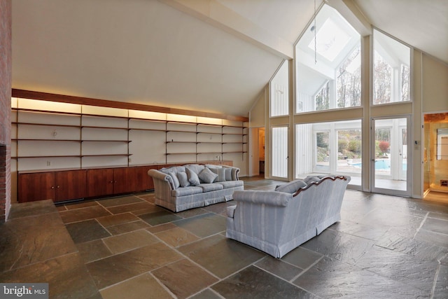 living room featuring high vaulted ceiling and dark tile floors