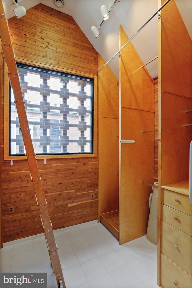 spacious closet with lofted ceiling and light tile flooring