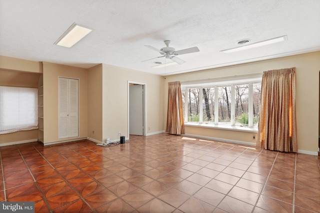 tiled spare room with ceiling fan