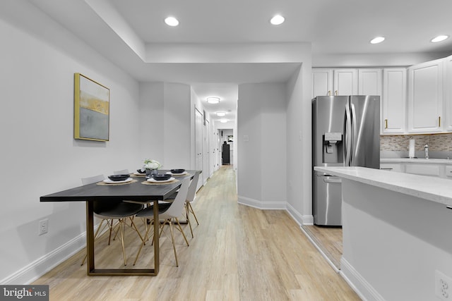 dining room with sink and light wood-type flooring