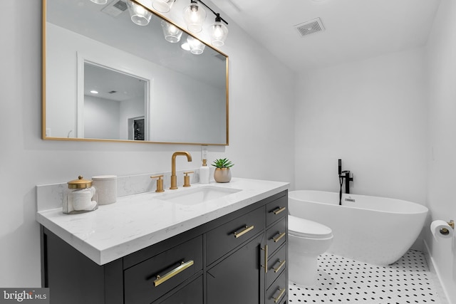 bathroom with tile patterned flooring, a washtub, vanity, and toilet